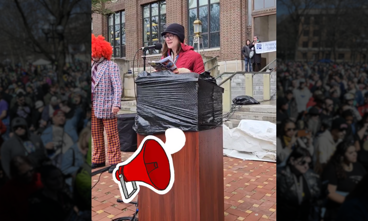 Woman speaking infront of a podium to a crowd in ann arbor michigan